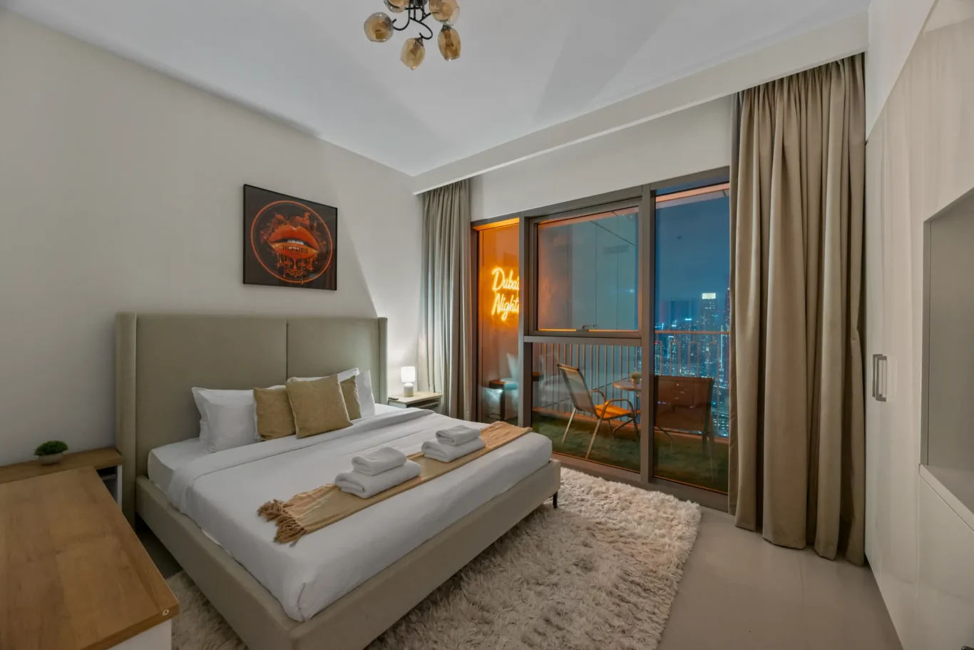 Living room and dining area at twilight with warm lights. Day, twilight and night Airbnb photography by MRPS for Vista Haus Holiday Homes in Downtown Dubai.