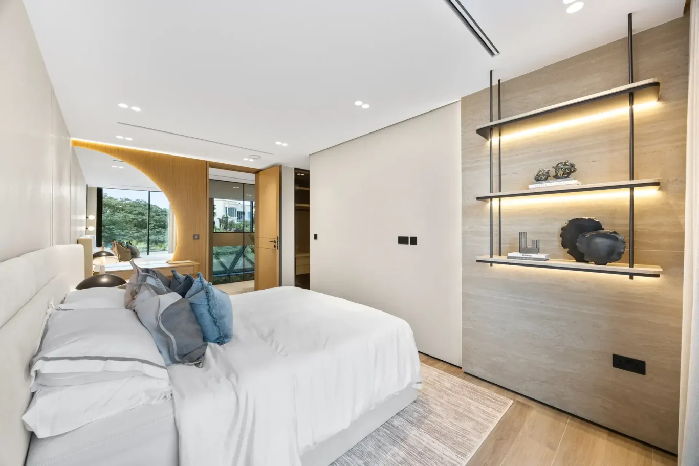 Bedroom with lit shelving and a curved wood arch, luxury villa in Jumeirah Islands, Dubai.