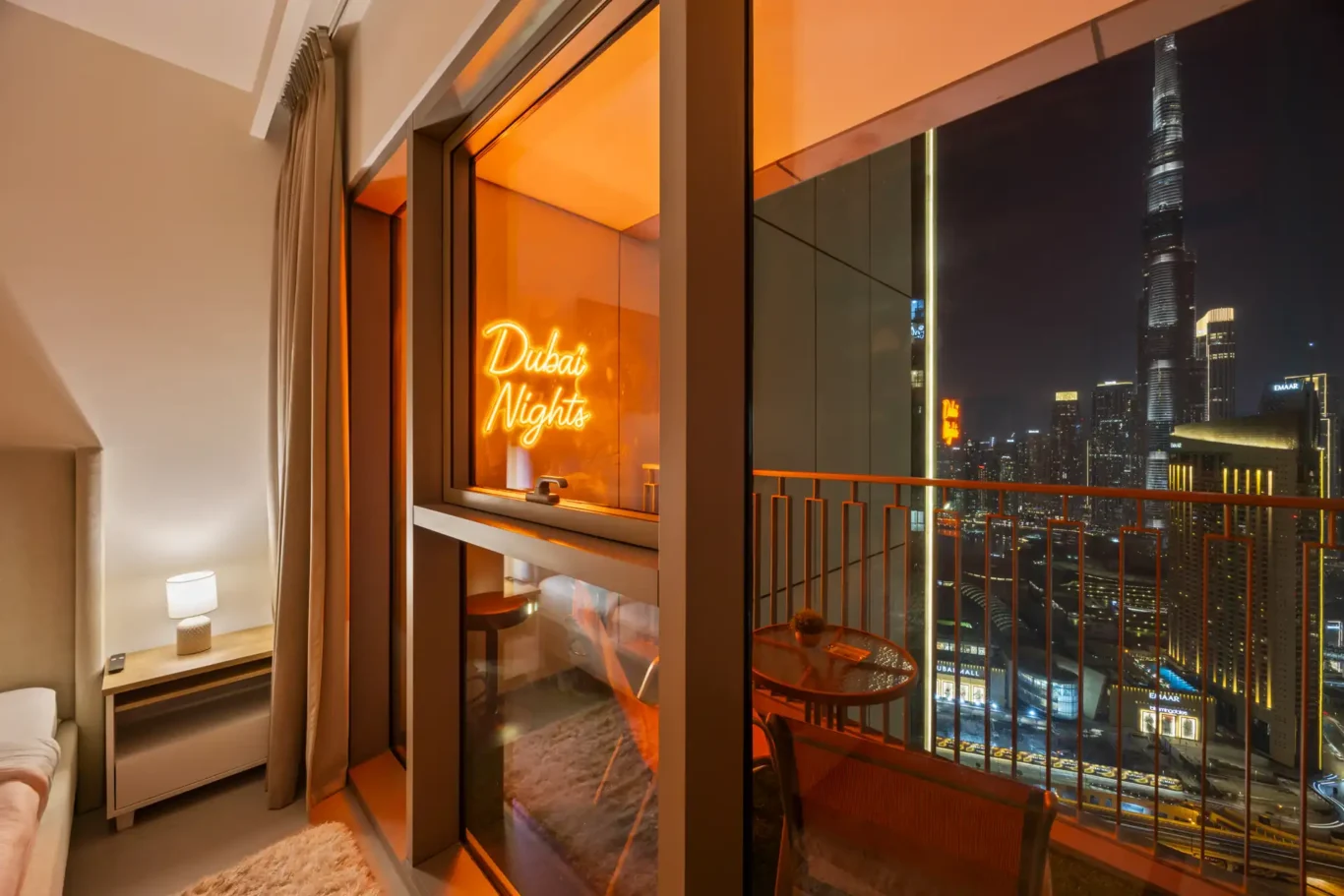 Master bedroom at twilight with the city lights through the window. Day, twilight and night Airbnb photography by MRPS for Vista Haus Holiday Homes in Downtown Dubai.