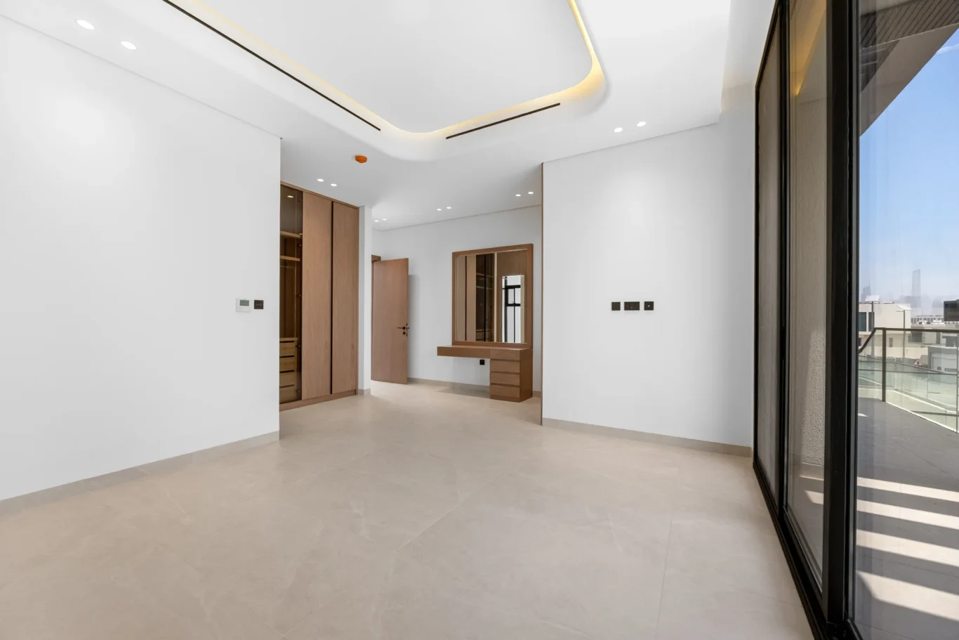 Bedroom looking towards the wardrobe and balcony, unfurnished five-bedroom villa in Al Furjan, Dubai.