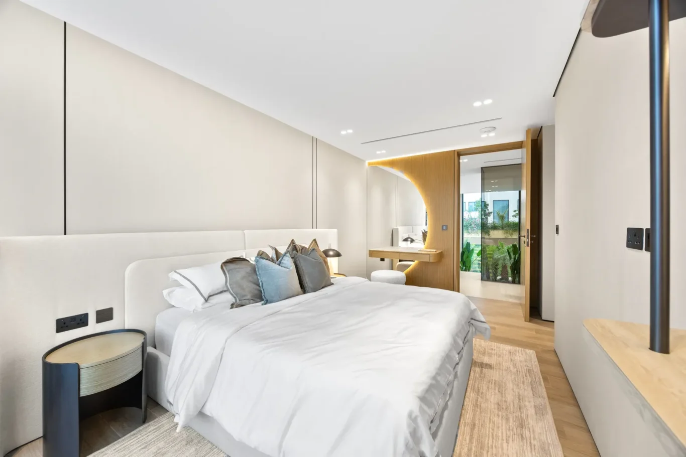 Bedroom bed with blue cushions and a bedside table, luxury villa in Jumeirah Islands, Dubai.