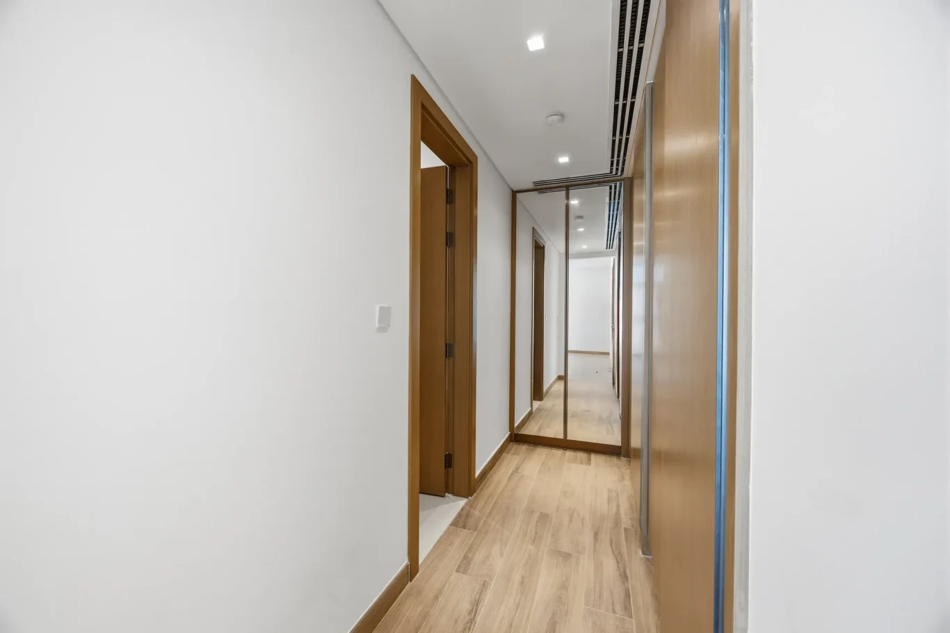 Third bedroom with wood flooring and balcony door. Villa photography by MRPS in Dubai for ELITE Property Brokerage.