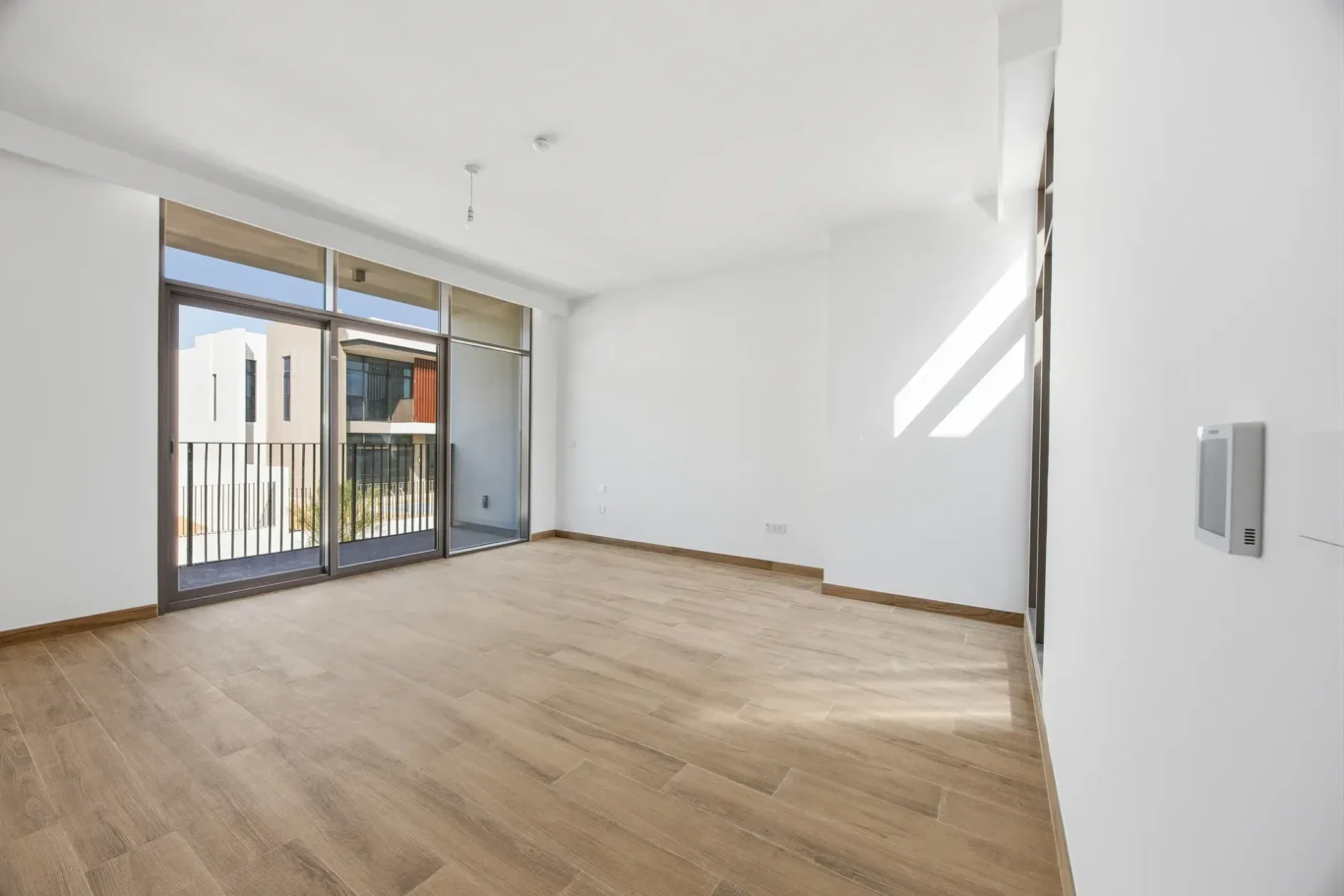 Fourth bedroom with large window and wood flooring. Villa photography by MRPS in Dubai for ELITE Property Brokerage.