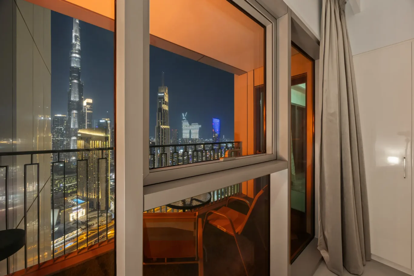 Master bedroom at twilight with the Burj Khalifa in the window. Day, twilight and night Airbnb photography by MRPS for Vista Haus Holiday Homes in Downtown Dubai.