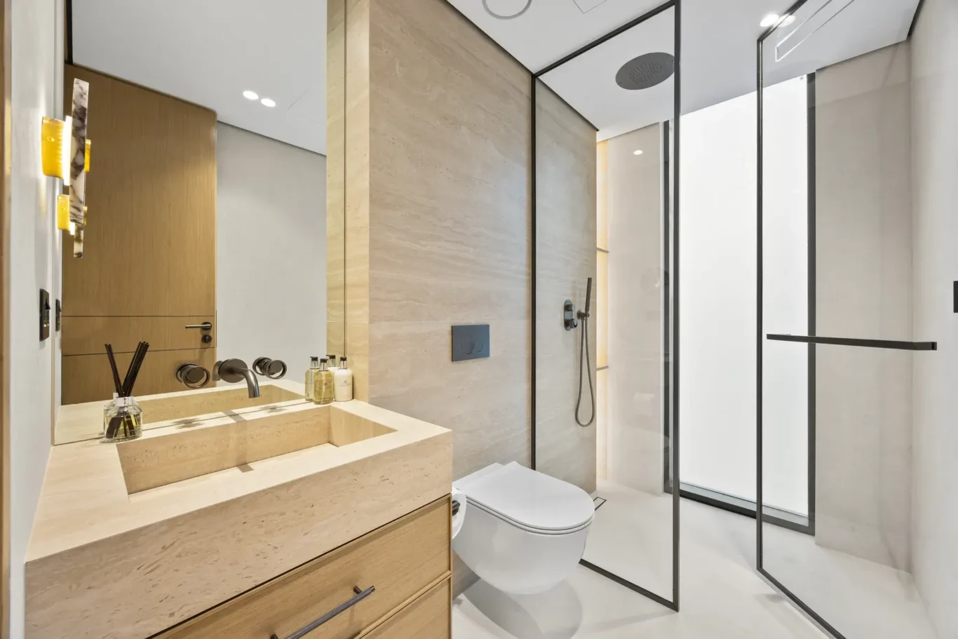 En-suite bathroom with a stone vanity and glass shower, luxury villa in Jumeirah Islands, Dubai.