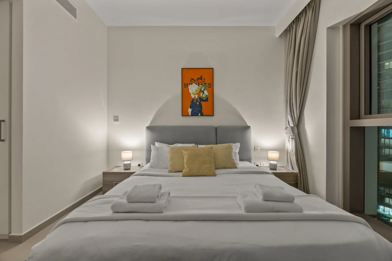 Bedroom at twilight with the Downtown Dubai towers lit up. Day, twilight and night Airbnb photography by MRPS for Vista Haus Holiday Homes in Downtown Dubai.