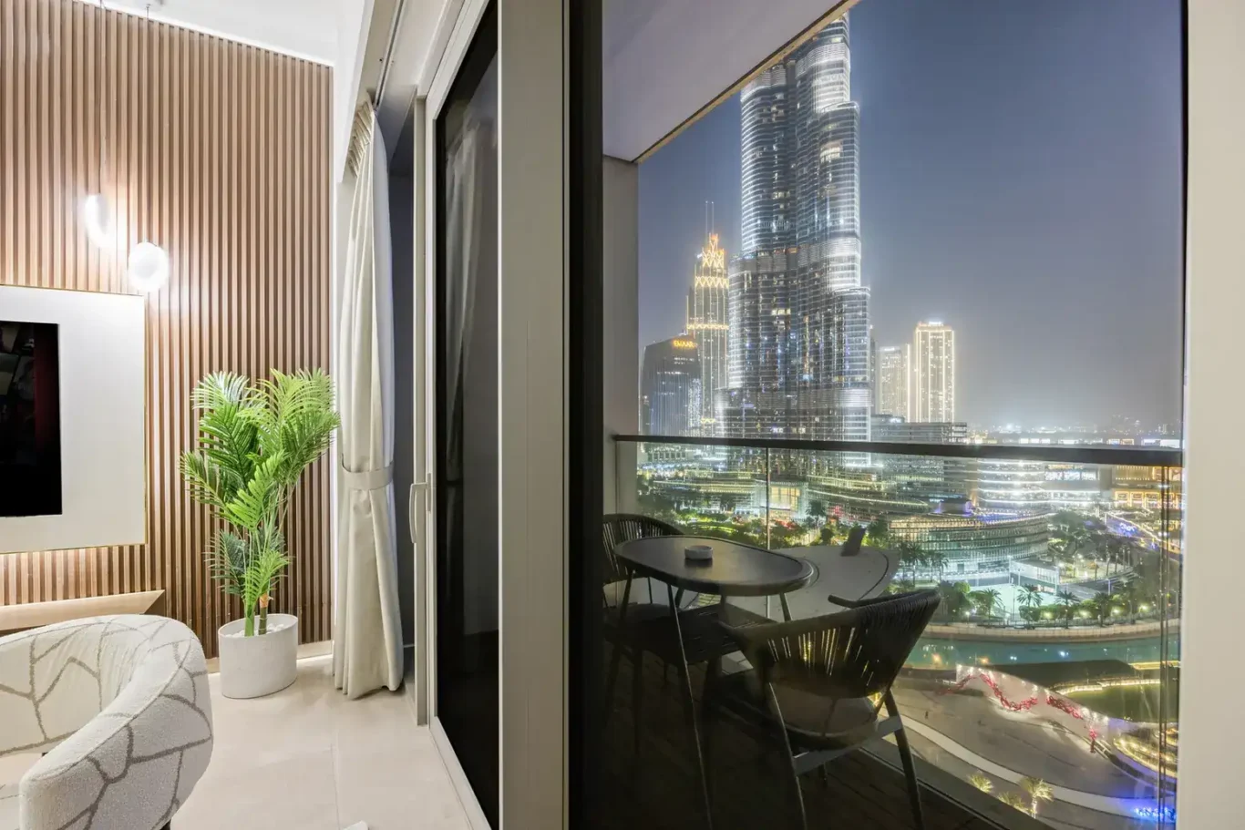 Living room with Burj Khalifa at night in a two-bedroom StayComfy Holiday Homes apartment at Grande Signature, Downtown Dubai.