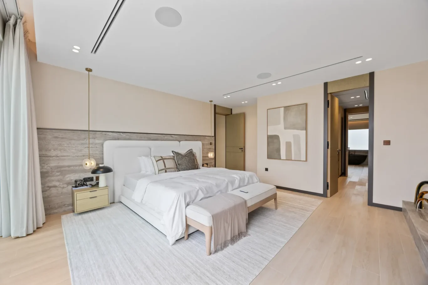 Wide view of the master bedroom with artwork and pendant lights, luxury villa in Jumeirah Islands, Dubai.