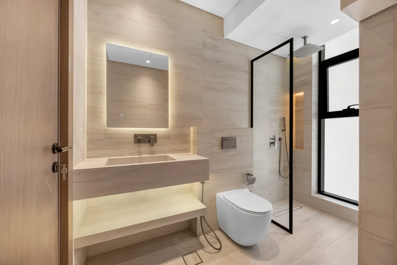 En-suite bathroom with a lit mirror and glass shower screen, unfurnished five-bedroom villa in Al Furjan, Dubai.