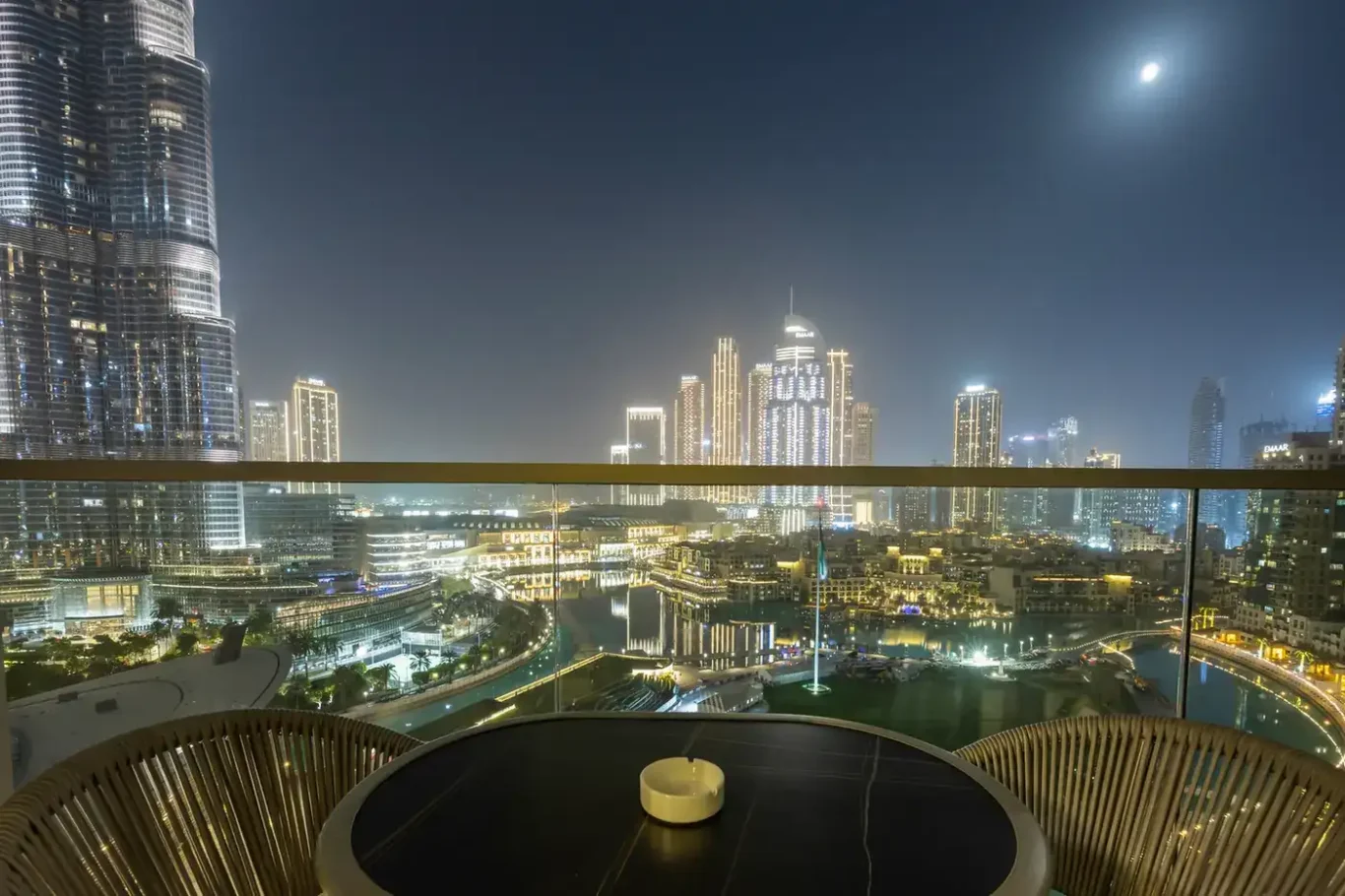 Balcony table with night skyline in a two-bedroom StayComfy Holiday Homes apartment at Grande Signature, Downtown Dubai.
