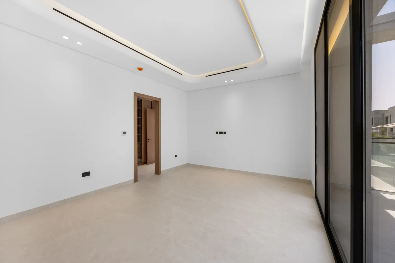 Wide view of an empty bedroom with cove lighting, unfurnished five-bedroom villa in Al Furjan, Dubai.