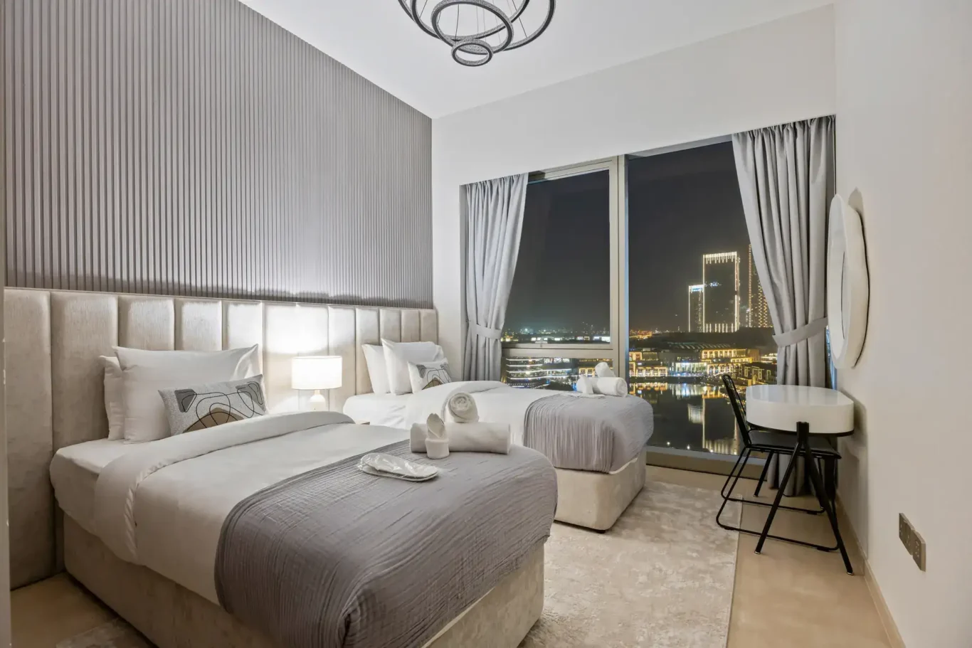 Twin bedroom at night in a two-bedroom StayComfy Holiday Homes apartment at Grande Signature, Downtown Dubai.