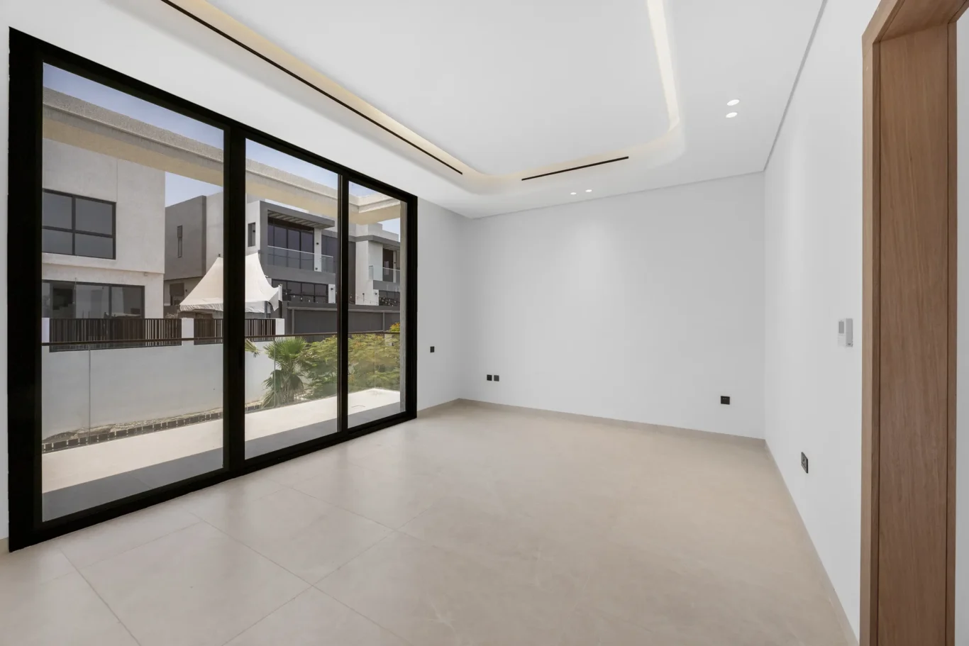 Master bedroom with wide sliding doors to the terrace, unfurnished five-bedroom villa in Al Furjan, Dubai.