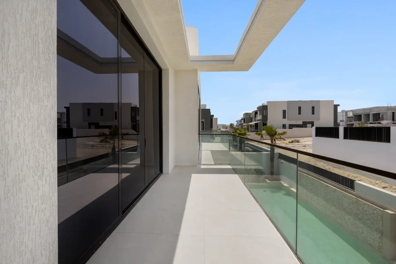 Master terrace with a glass balustrade above the pool, unfurnished five-bedroom villa in Al Furjan, Dubai.