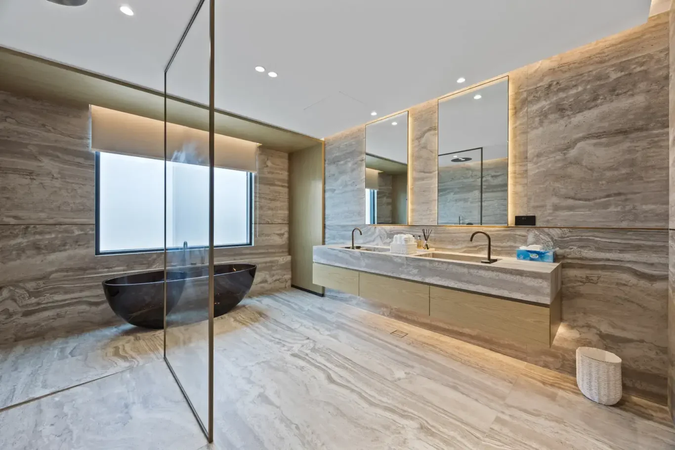 Master bathroom with a stone bathtub and a vanity with lit mirrors, luxury villa in Jumeirah Islands, Dubai.