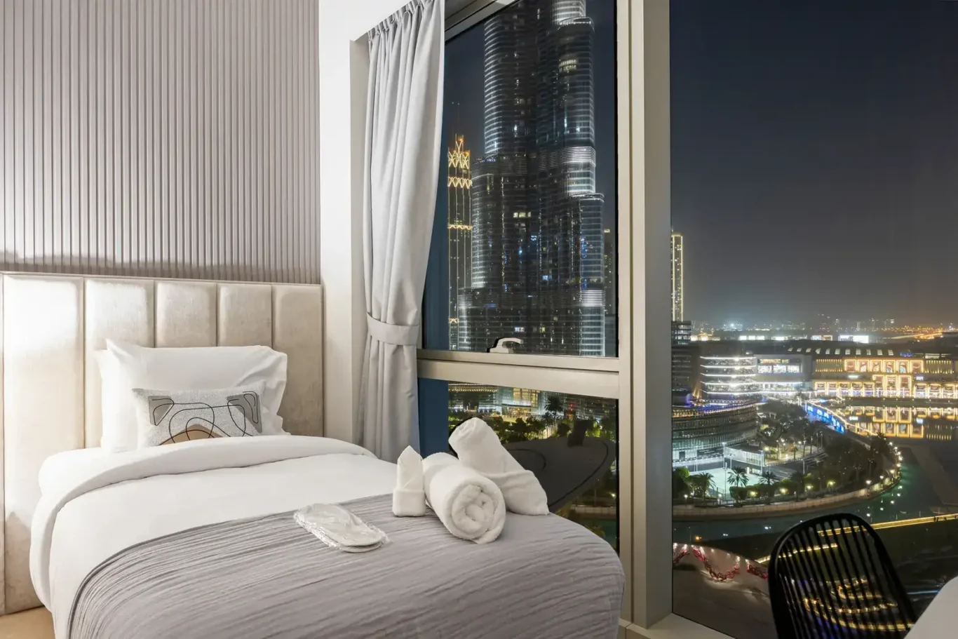 Twin bedroom night city lights in a two-bedroom StayComfy Holiday Homes apartment at Grande Signature, Downtown Dubai.