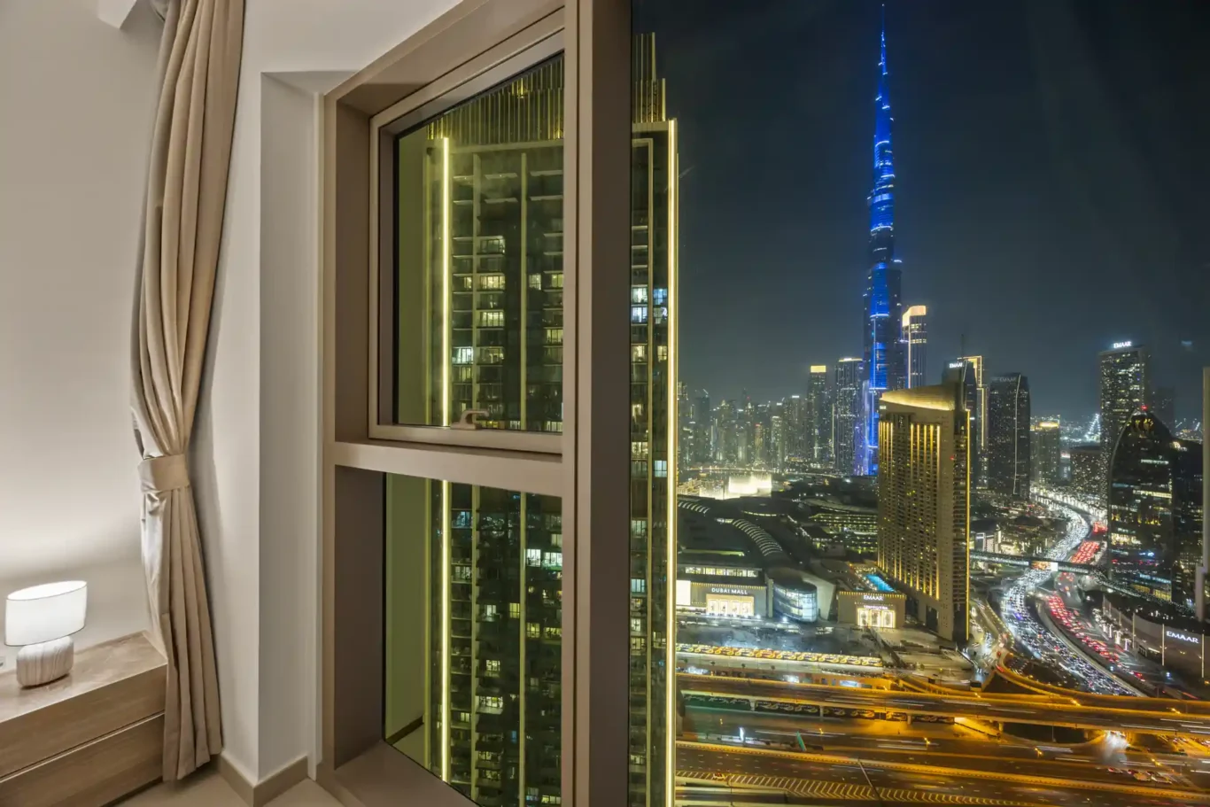 Night skyline with the Burj Khalifa and Dubai Mall lights from the balcony. Day, twilight and night Airbnb photography by MRPS for Vista Haus Holiday Homes in Downtown Dubai.