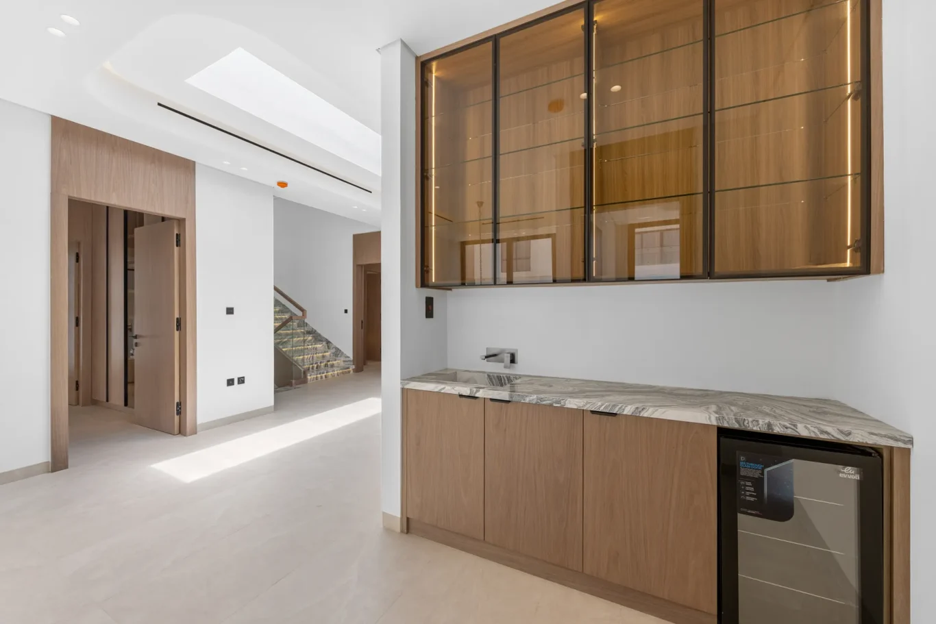 First floor pantry with glass cabinets and a wine fridge, unfurnished five-bedroom villa in Al Furjan, Dubai.