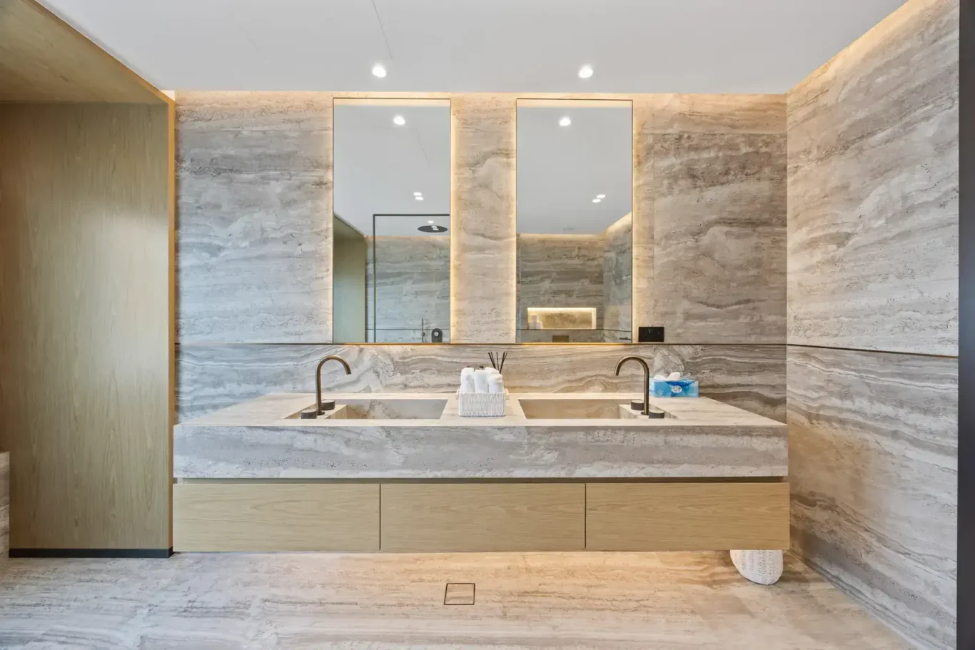 Master bathroom double vanity with twin mirrors and stone walls, luxury villa in Jumeirah Islands, Dubai.