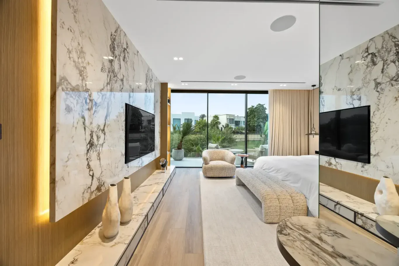 Master bedroom marble TV wall with a view to the terrace, luxury villa in Jumeirah Islands, Dubai.