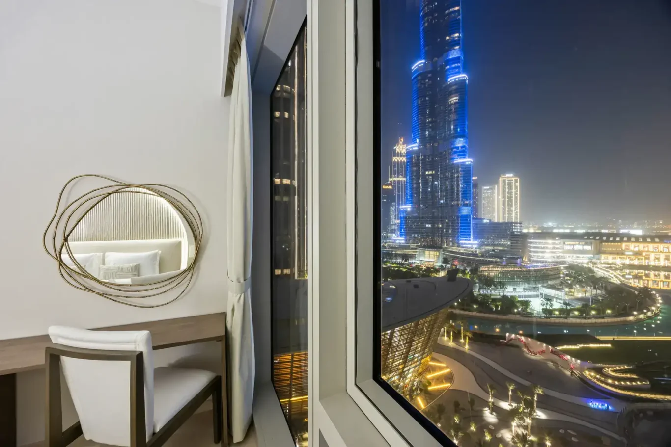 Desk with Burj Khalifa lit at night in a two-bedroom StayComfy Holiday Homes apartment at Grande Signature, Downtown Dubai.