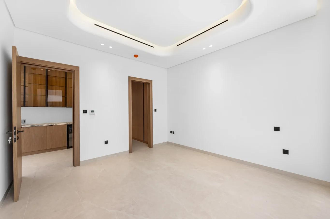 Bedroom with a door through to the pantry, unfurnished five-bedroom villa in Al Furjan, Dubai.
