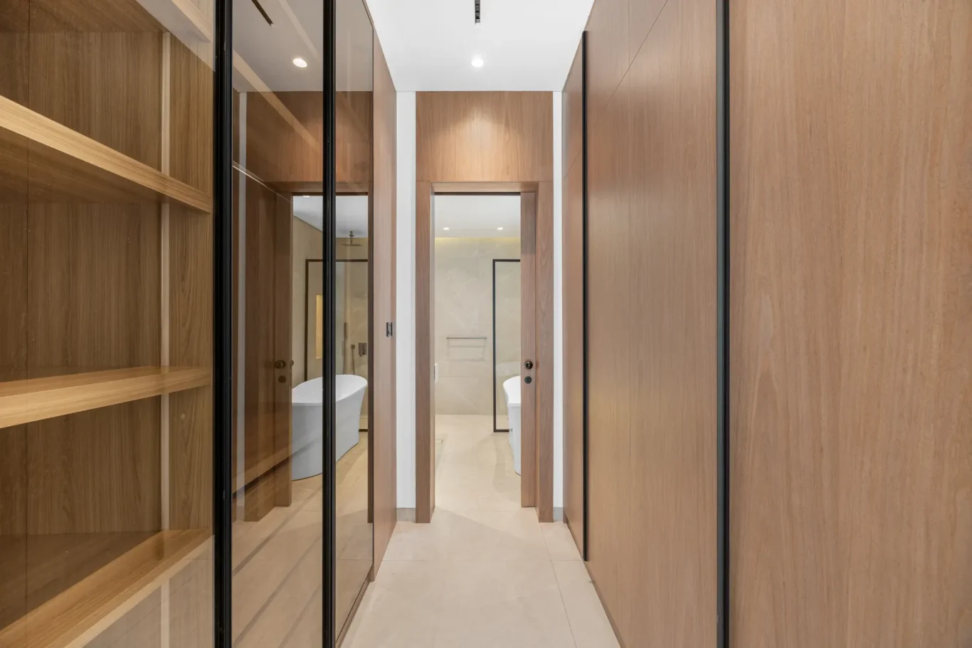 Walk-in wardrobe with open walnut shelving, unfurnished five-bedroom villa in Al Furjan, Dubai.
