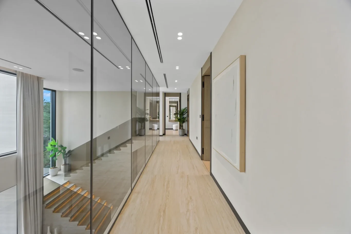 Upper corridor with glass walls and artwork, luxury villa in Jumeirah Islands, Dubai.