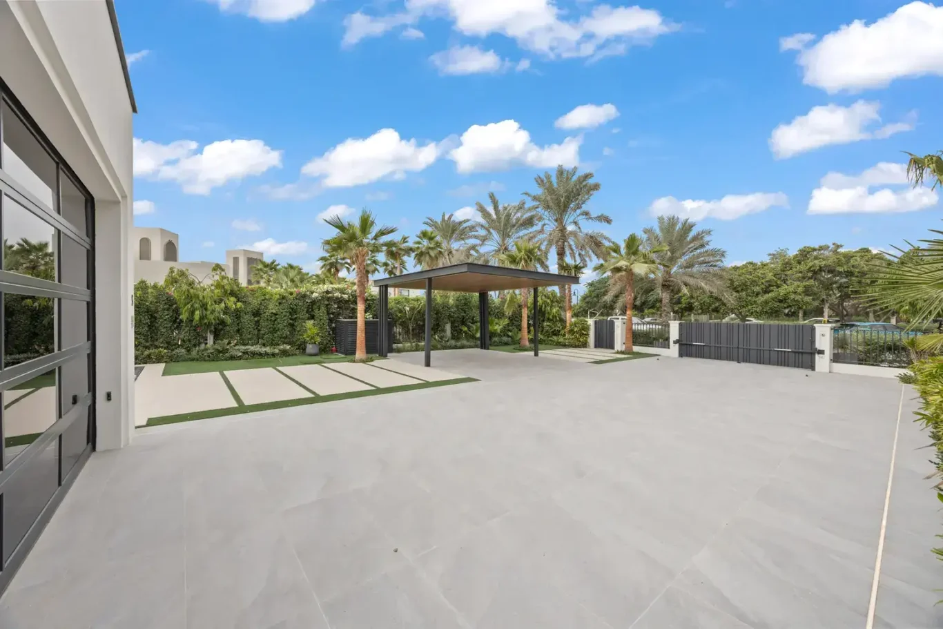 Front driveway and carport with landscaped borders, luxury villa in Jumeirah Islands, Dubai.