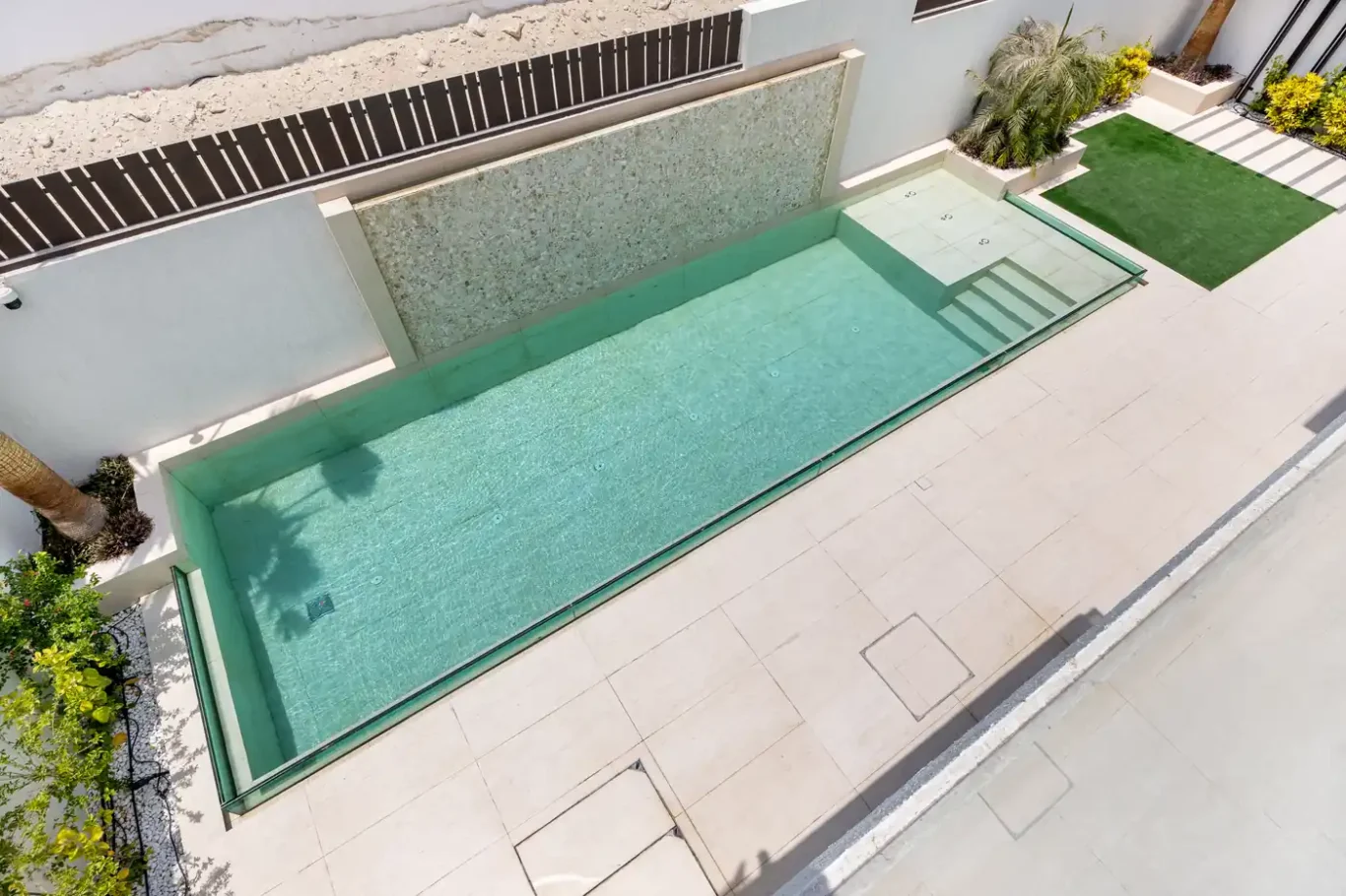 Swimming pool and water wall seen from above, unfurnished five-bedroom villa in Al Furjan, Dubai.