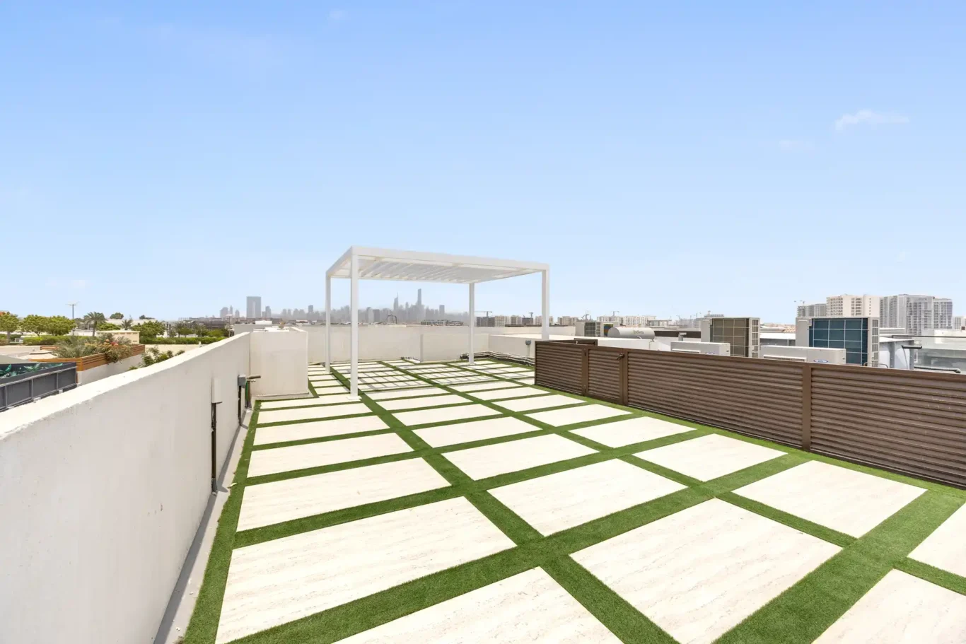 Roof terrace with paving, artificial grass and a skyline view, unfurnished five-bedroom villa in Al Furjan, Dubai.