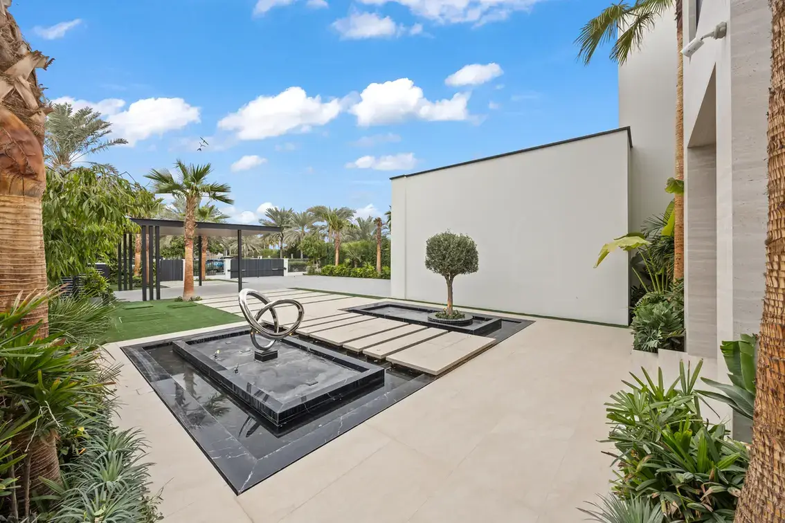Front garden water feature with a sculpture and landscaping, luxury villa in Jumeirah Islands, Dubai.
