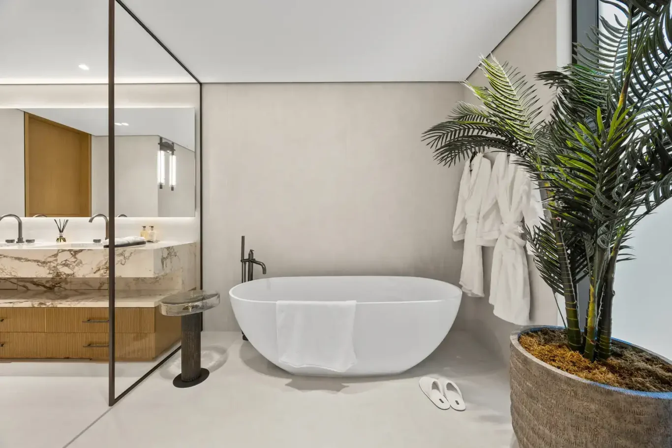 Freestanding bathtub with a floor tap, bathrobes and a palm, luxury villa in Jumeirah Islands, Dubai.