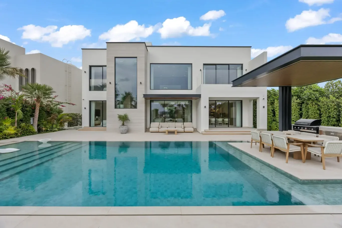 Rear exterior with the swimming pool and outdoor dining pergola, luxury villa in Jumeirah Islands, Dubai.