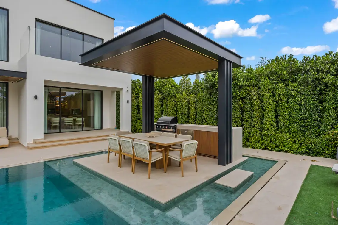 Outdoor dining pergola with a barbecue beside the pool, luxury villa in Jumeirah Islands, Dubai.