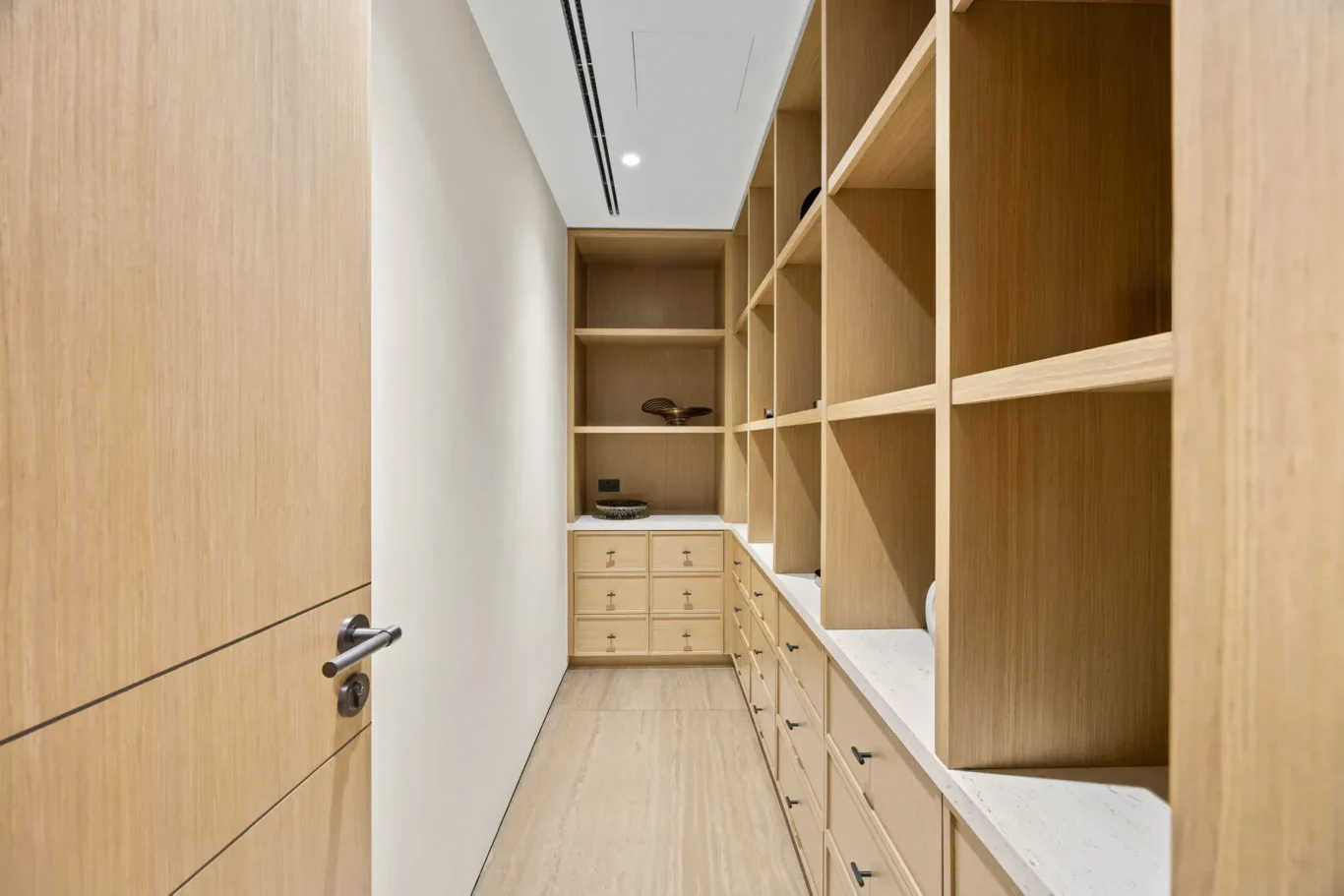 Pantry storage room with wood shelving and drawers, luxury villa in Jumeirah Islands, Dubai.