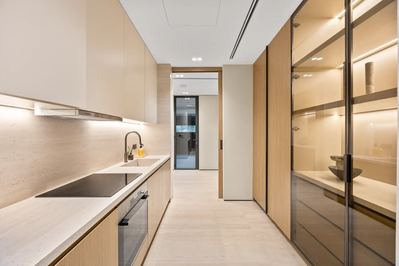 Service kitchen with a stone counter and glass-front cabinets, luxury villa in Jumeirah Islands, Dubai.