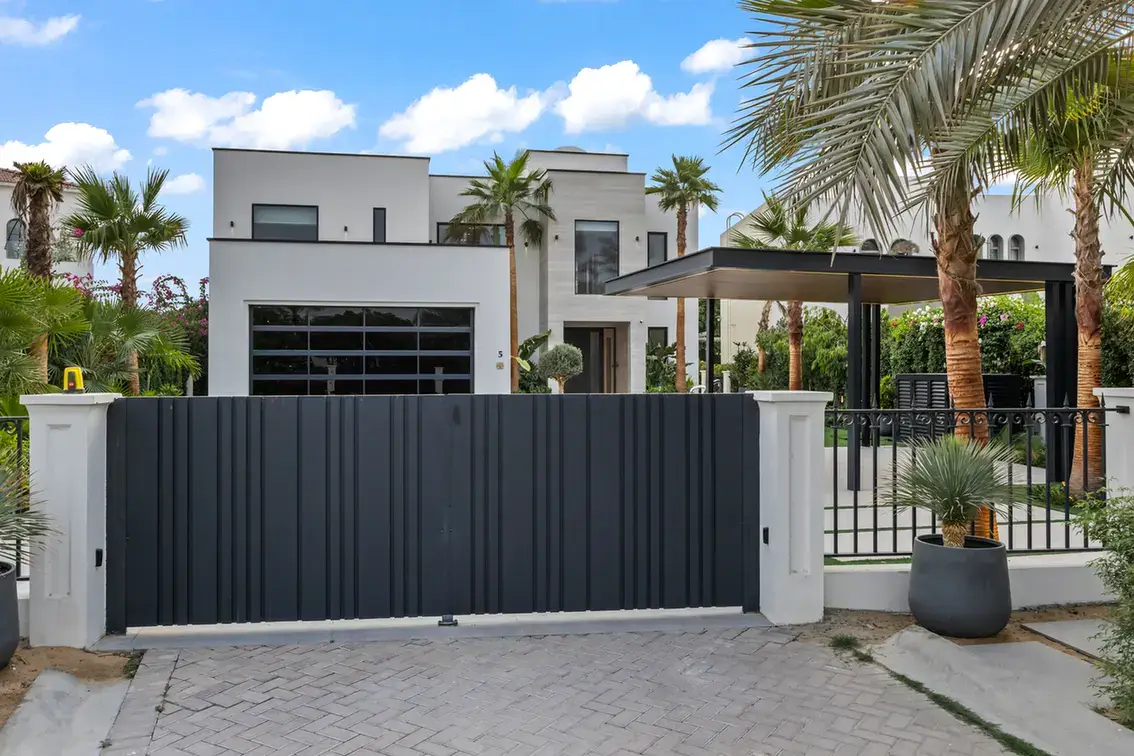 Villa entrance gate and front exterior seen from the street, luxury villa in Jumeirah Islands, Dubai.