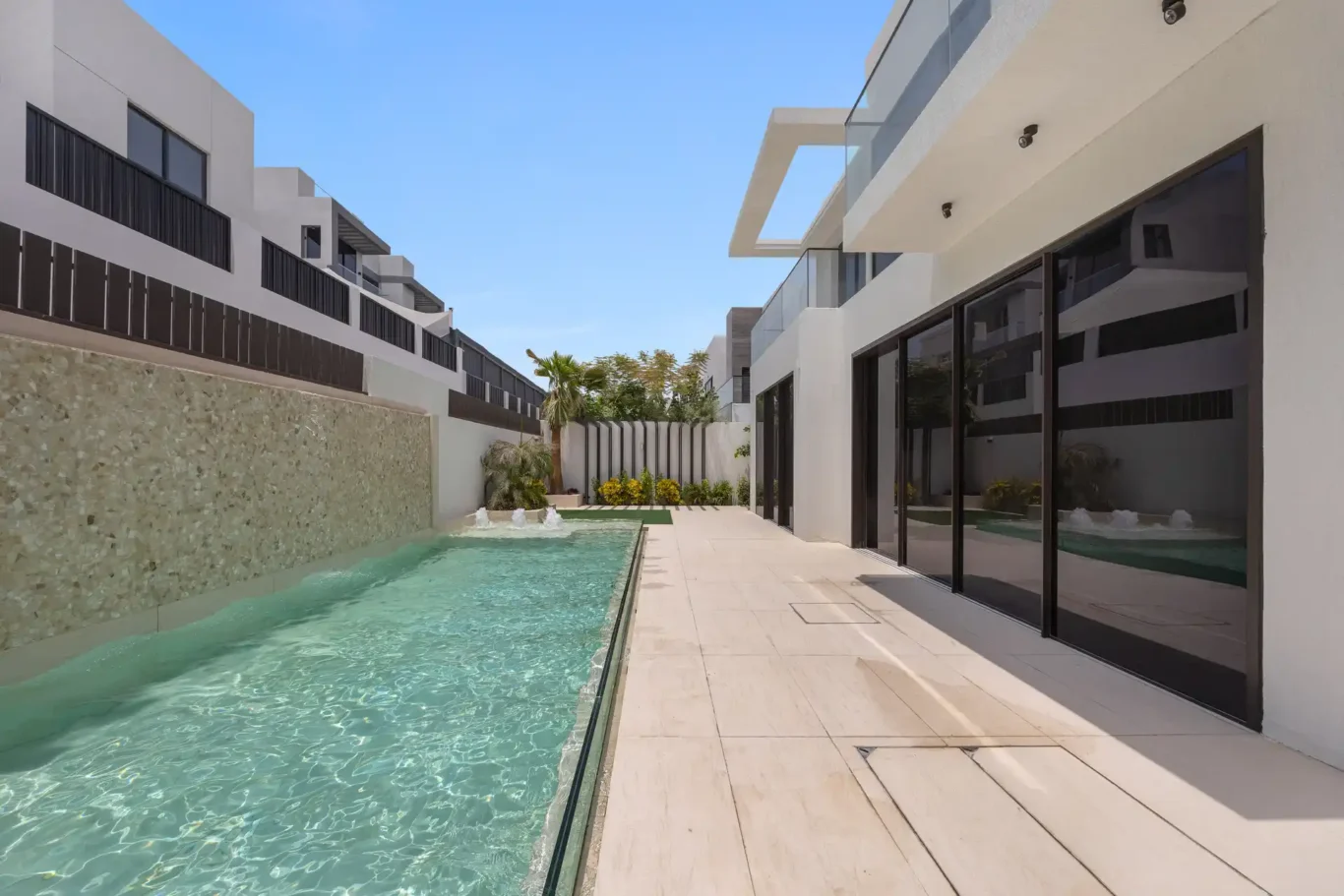 Pool terrace beside the living room glass doors, unfurnished five-bedroom villa in Al Furjan, Dubai.