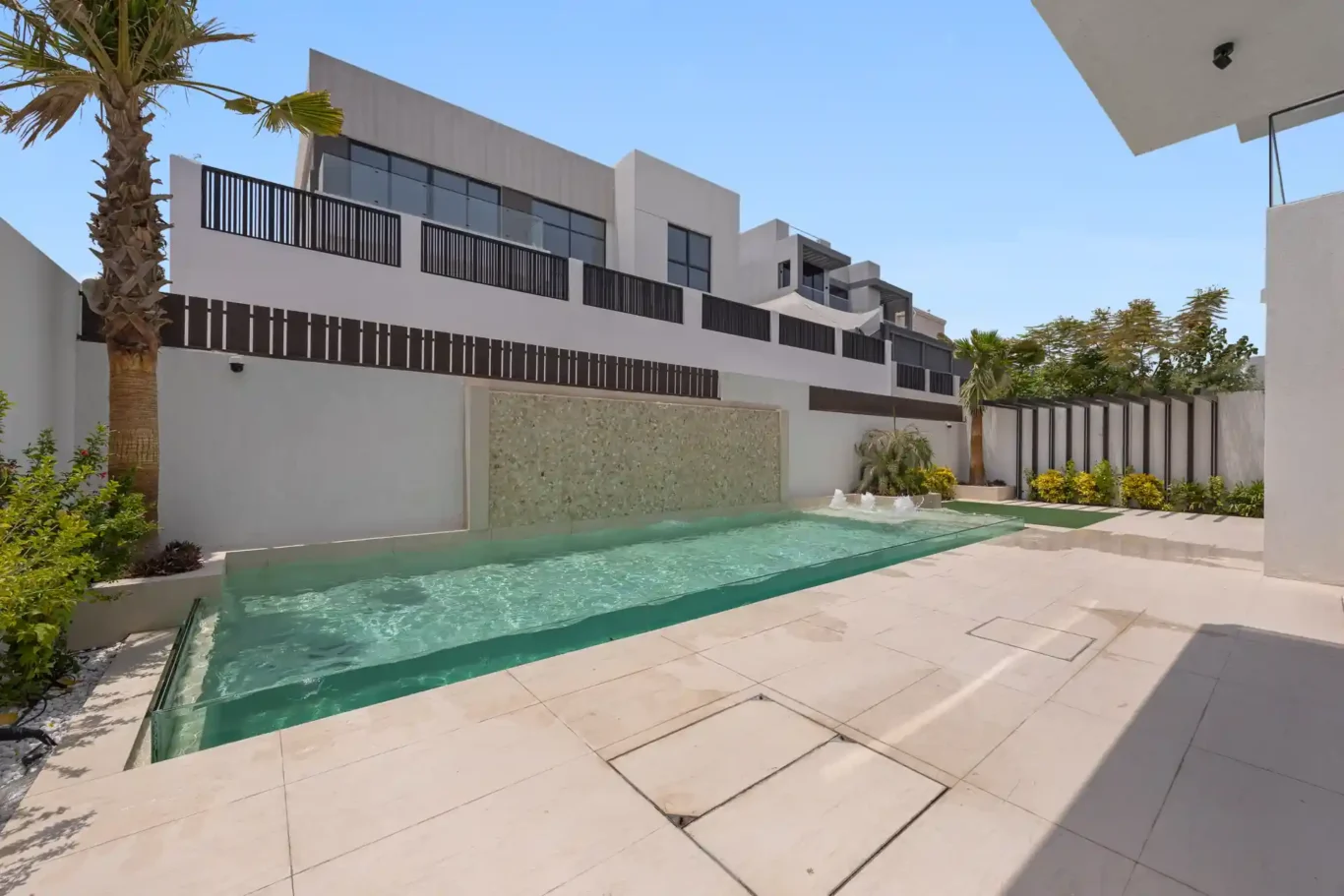 Swimming pool and terrace with a palm tree, unfurnished five-bedroom villa in Al Furjan, Dubai.