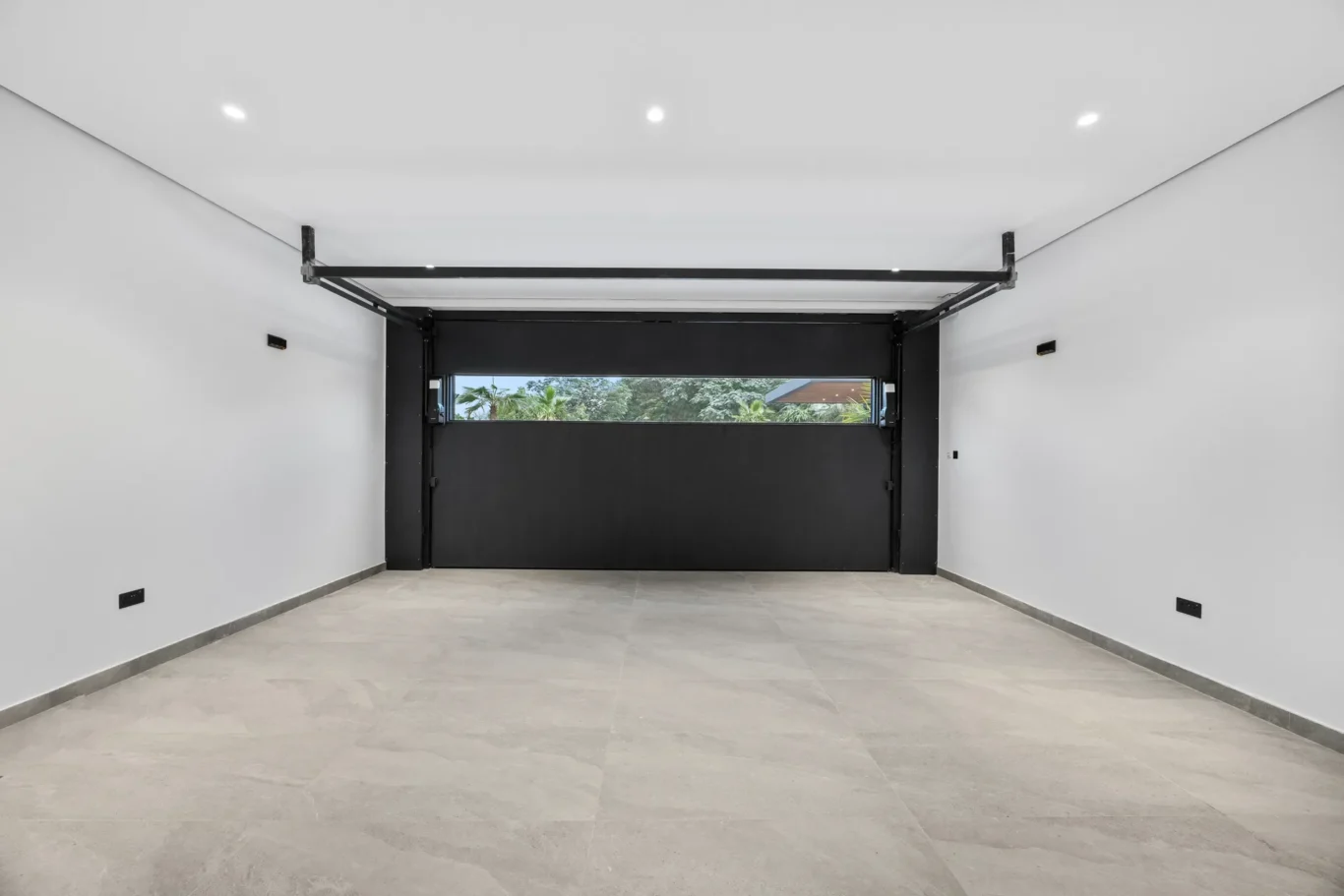 Empty garage with a glass sectional door, luxury villa in Jumeirah Islands, Dubai.