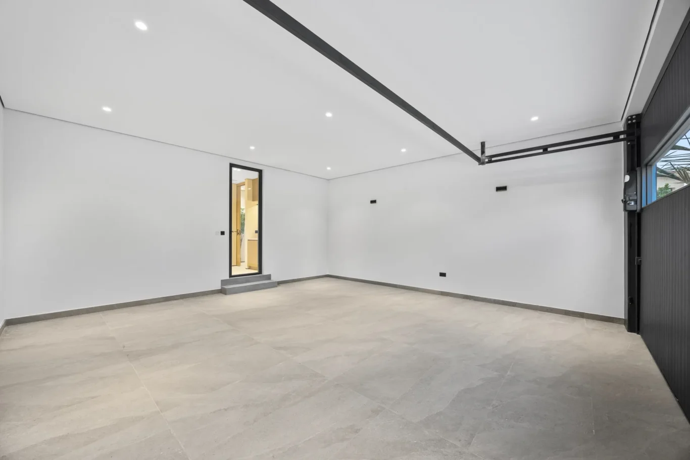 Garage interior with grey flooring and side door, luxury villa in Jumeirah Islands, Dubai.