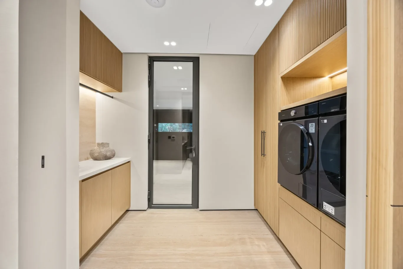 Laundry room with a washer, dryer and wood cabinets, luxury villa in Jumeirah Islands, Dubai.
