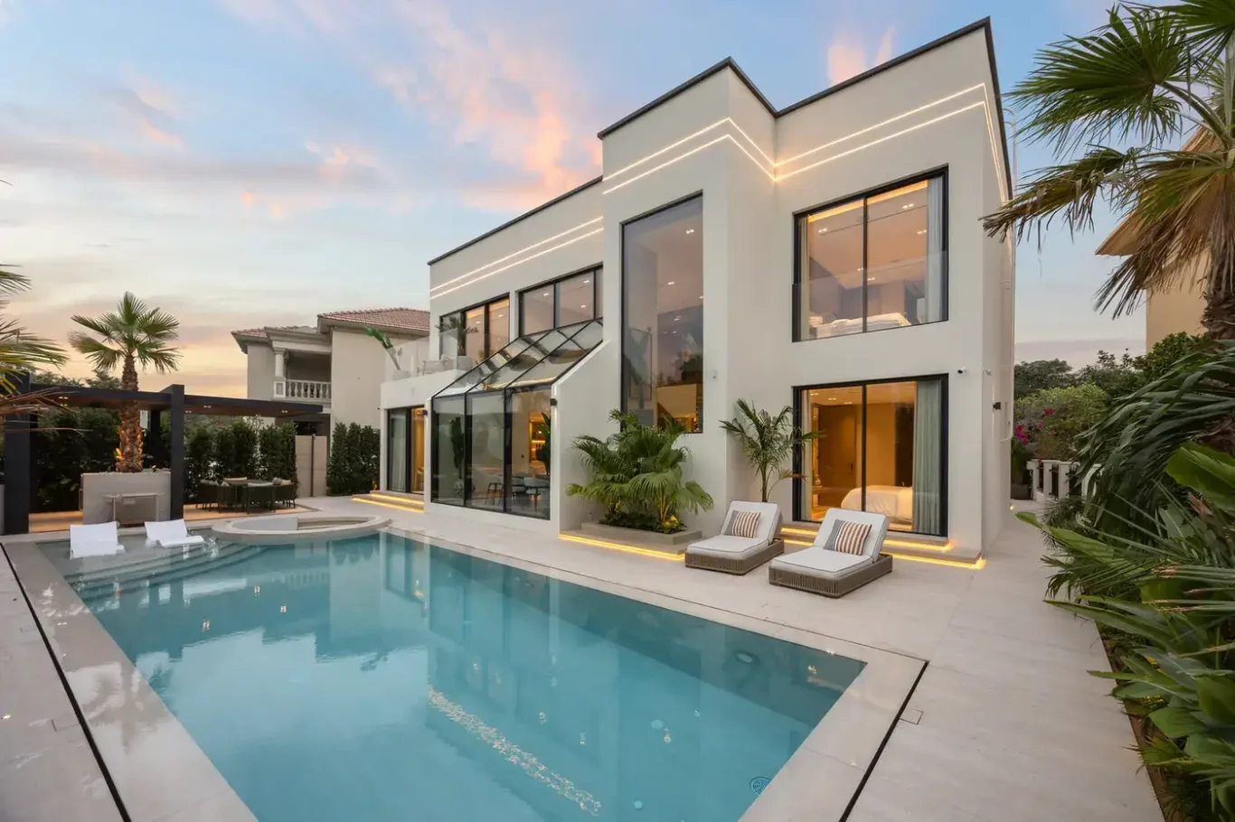 Rear exterior of the villa at sunset with the swimming pool, luxury villa in Jumeirah Islands, Dubai.