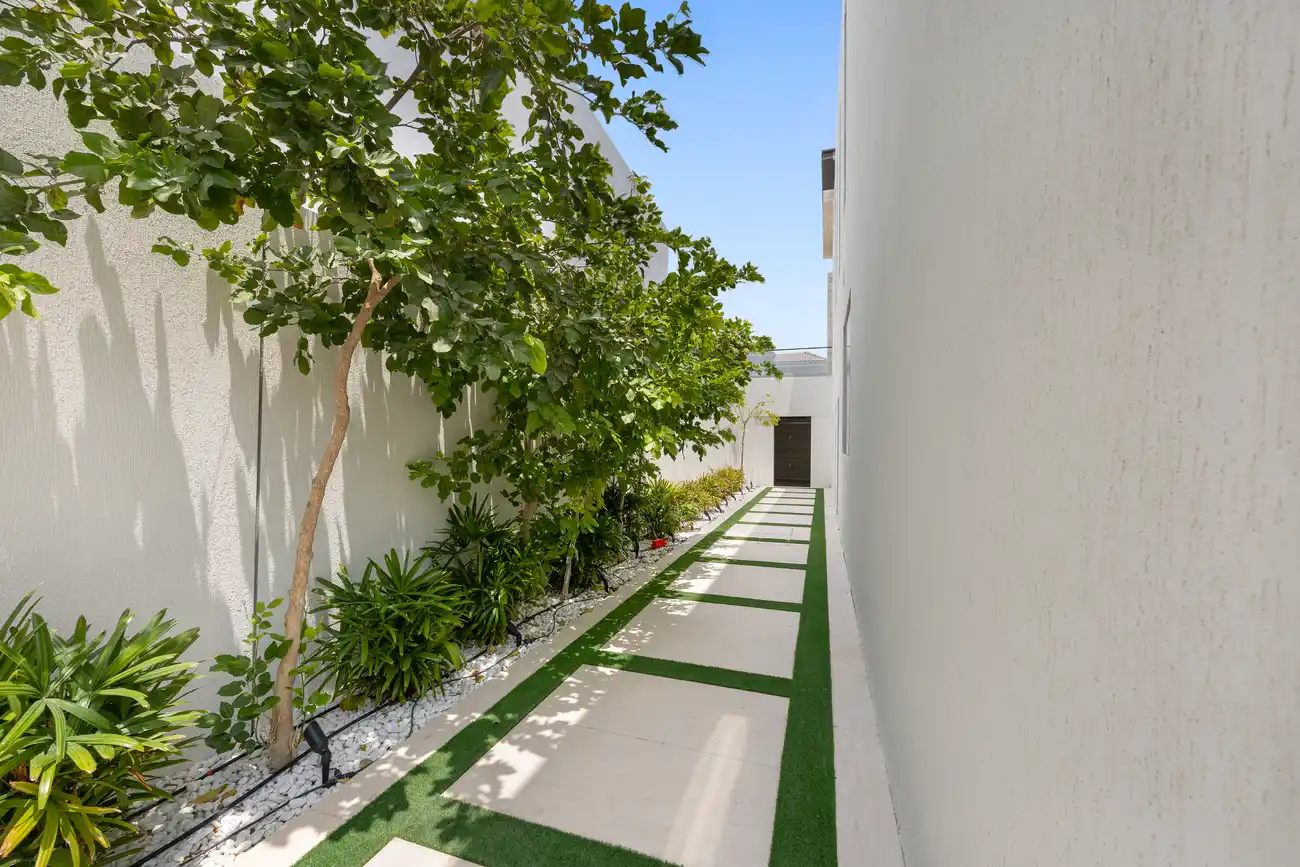 Side garden path with planting, unfurnished five-bedroom villa in Al Furjan, Dubai.