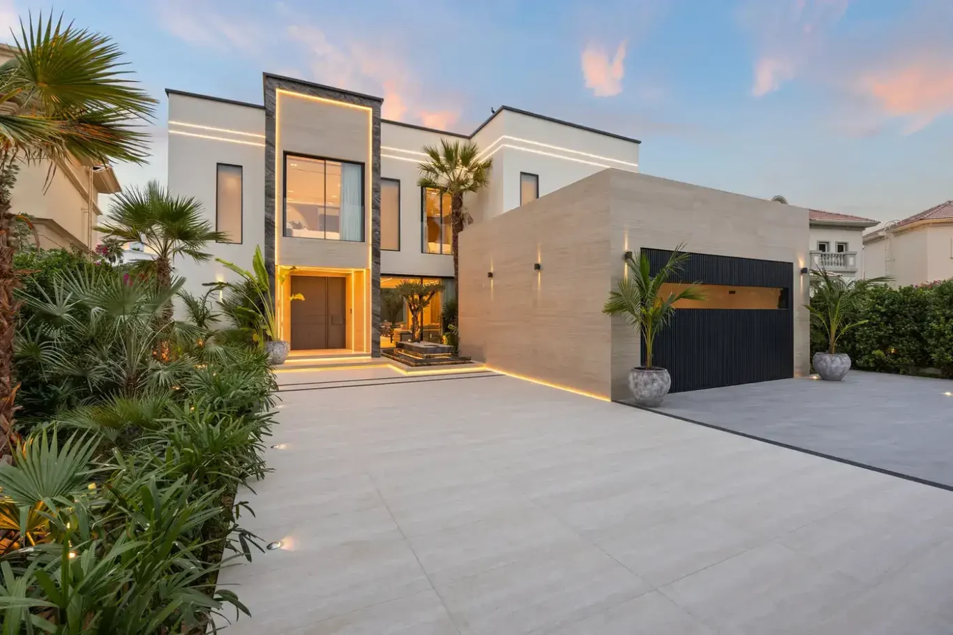 Front driveway and lit entrance at sunset, luxury villa in Jumeirah Islands, Dubai.