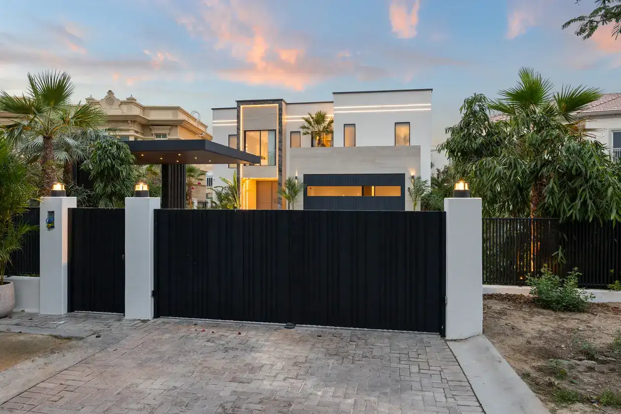 Villa entrance gate and facade from the street at sunset, luxury villa in Jumeirah Islands, Dubai.