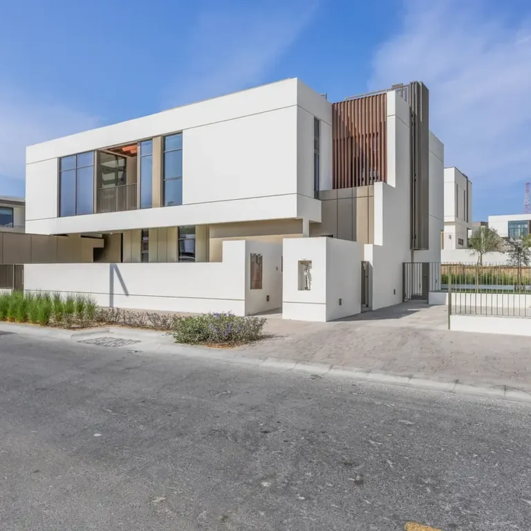 Front elevation of a brand new four bedroom villa in Tilal Al Furjan, white facade with timber accents. Villa photography by MRPS in Dubai for ELITE Property Brokerage.